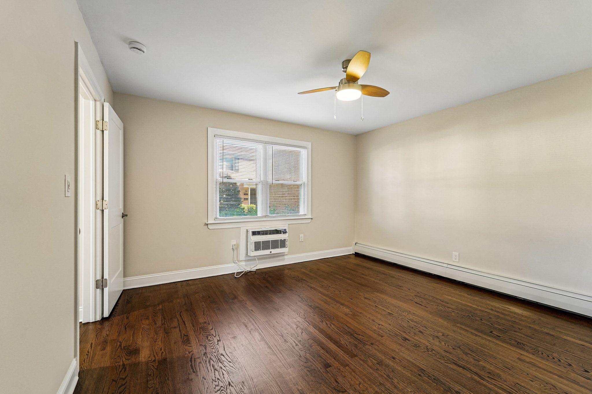 A room with a ceiling fan and a window.